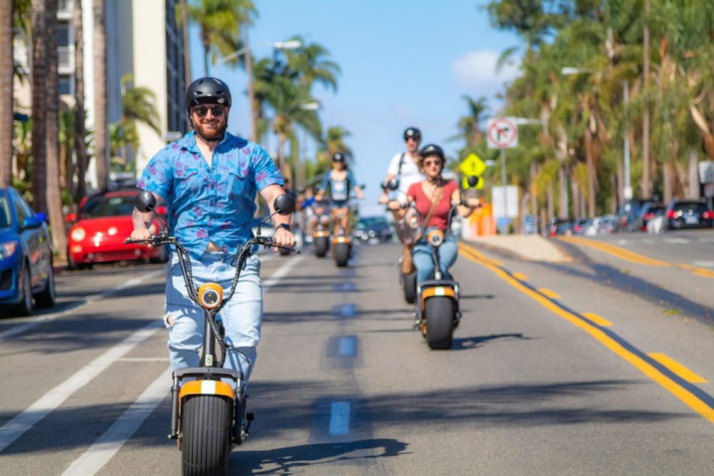 a man riding an electric scooter on a city street in San Diego