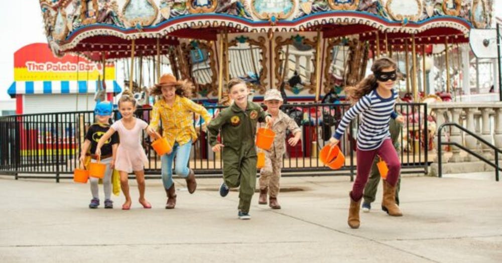 children running in front of carousel 