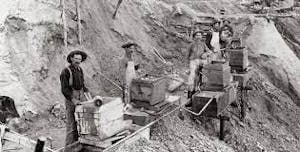 an old photo of a people working in a mine
