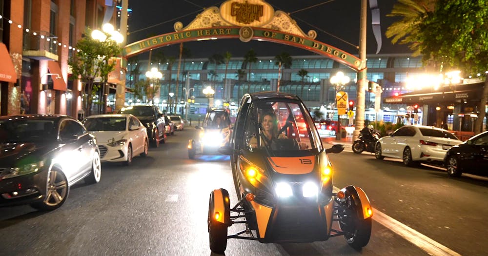 Gocar driving at night in front of historic Gaslamp sign