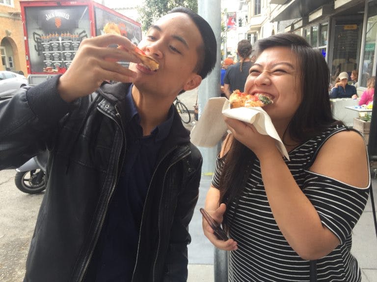 Food tour participants eating street food in New York City