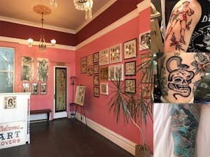 a display in a room with tattoo drawings in frames on the wall