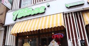 the storefront of a Chinese restaurant with a large lime green sign