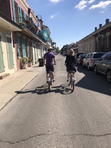a man and a woman riding down the street on bikes
