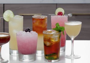 several colorful alcoholic beverages on a bar