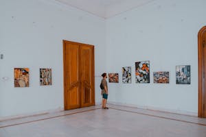 a man standing in a room looking at art