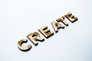 a close up of wooden letters that spell "create"