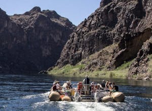 a group of people on a raft boating our in the Black Canyon