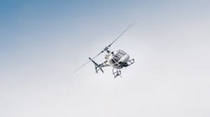 a helicopter flying high up in the air