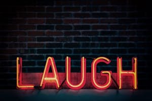 red and orange neon light sign "laugh" all uppercase