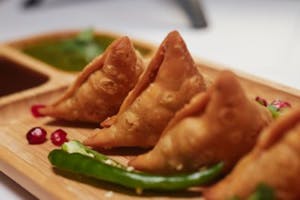 a close up of a plate of samosas