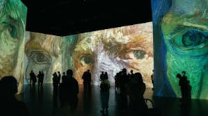 a group of people standing in an immersive Van Gogh art exhibit
