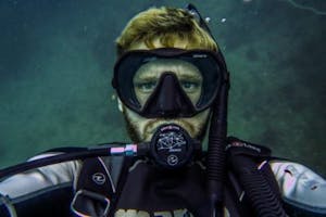 a guy under water with a mask and scuba equipment on