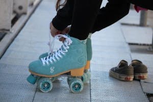 a person sitting on a bench putting on their rollerskates