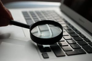 a close up of a magnifying glass and a computer keyboard