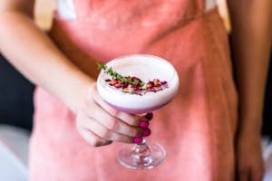 a fancy pink cocktail with rose petals