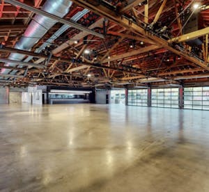 a modern event venue with cement floors and exposed wood beams