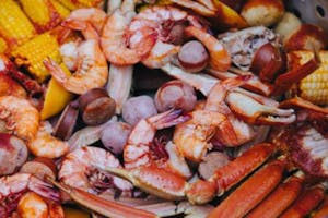 a shrimp boil with shrimp, sausage, corn and crab legs