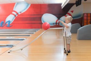 A child using a ramp for his bowling ball