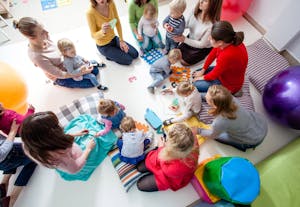 Overhead shot of women and babies with colorful toys at a playgroup