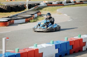 Someone driving a blue go-kart on a track