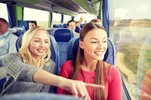 happy young women riding in travel bus