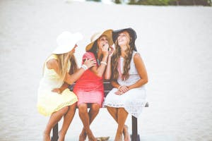 friends laughing in sunglasses in sun hats
