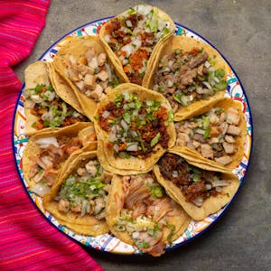 Assortment of Mexican tacos on grey background