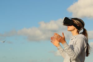 a woman using Virtual Reality goggles outdoors