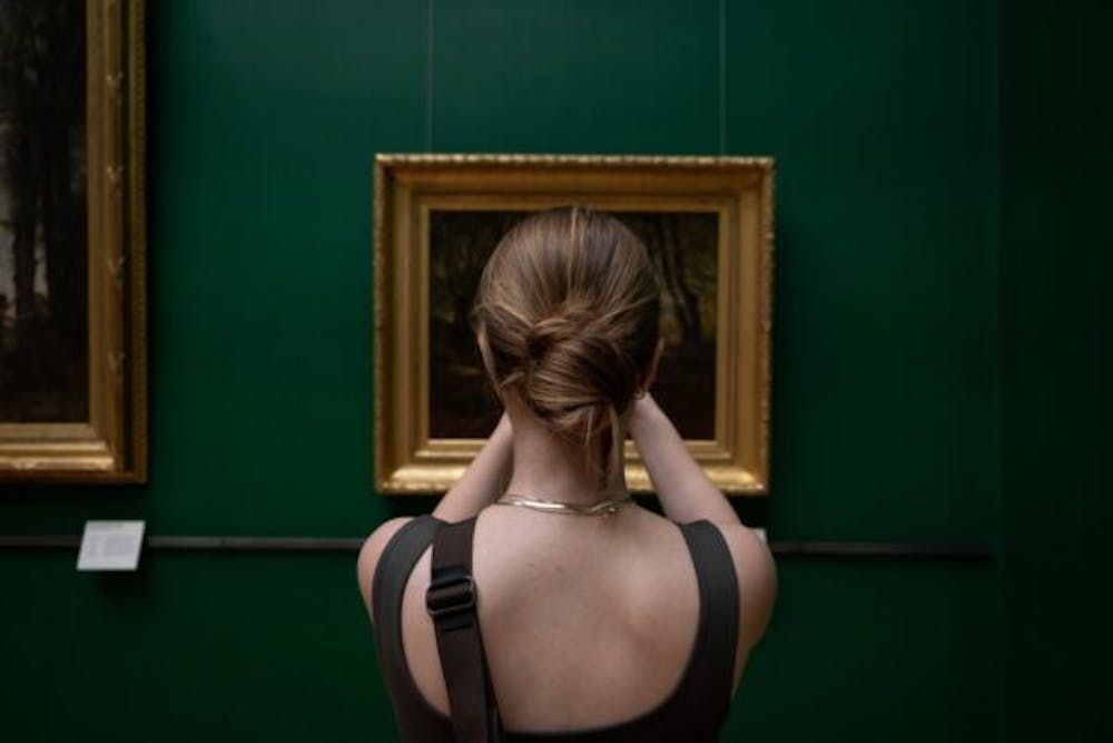 a woman standing in front of a piece of art in a museum