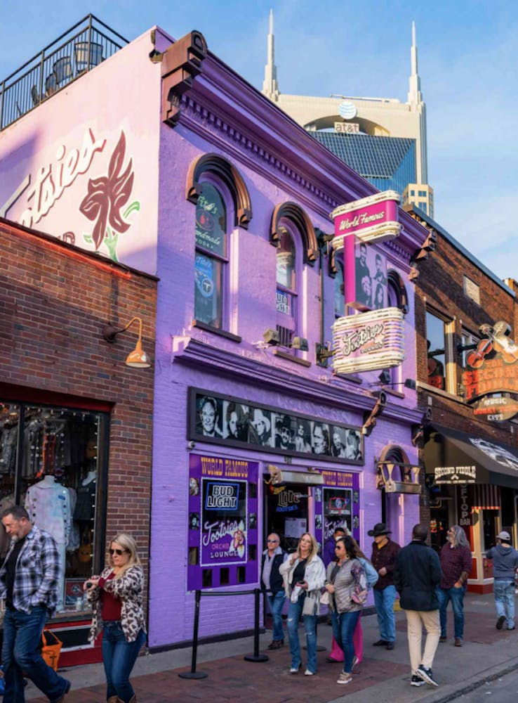 a group of people walking in front of a purple building in Nashville