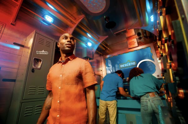 a person in an orange shirt standing in an escape room