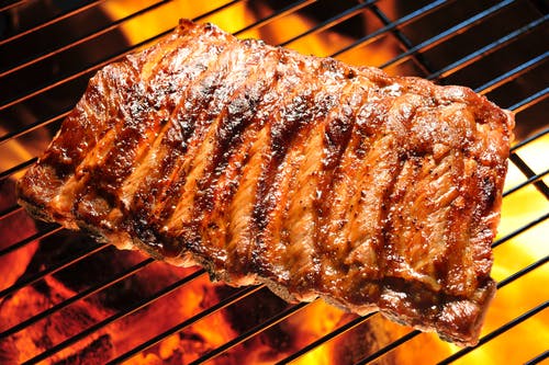 a close up of barbecue ribs on a grill