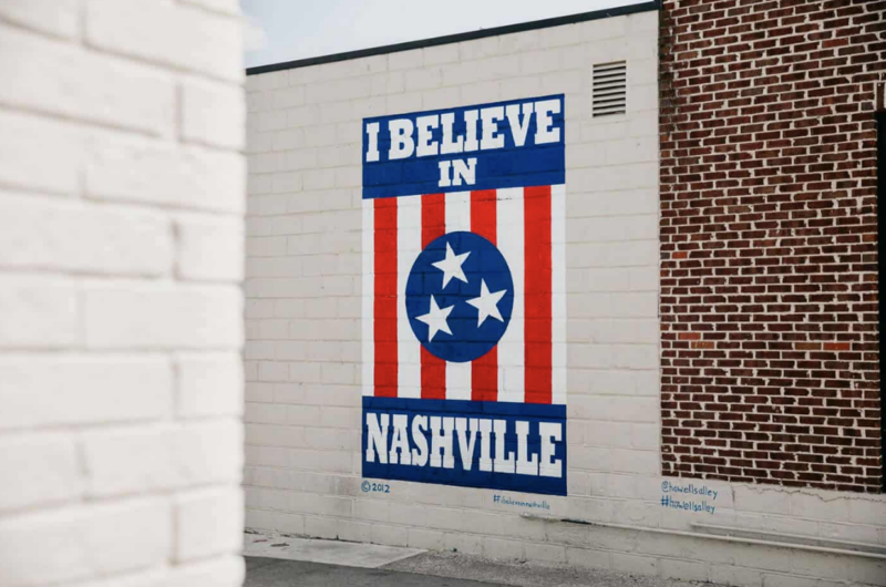 a sign with Nashville sign on the side of a brick building