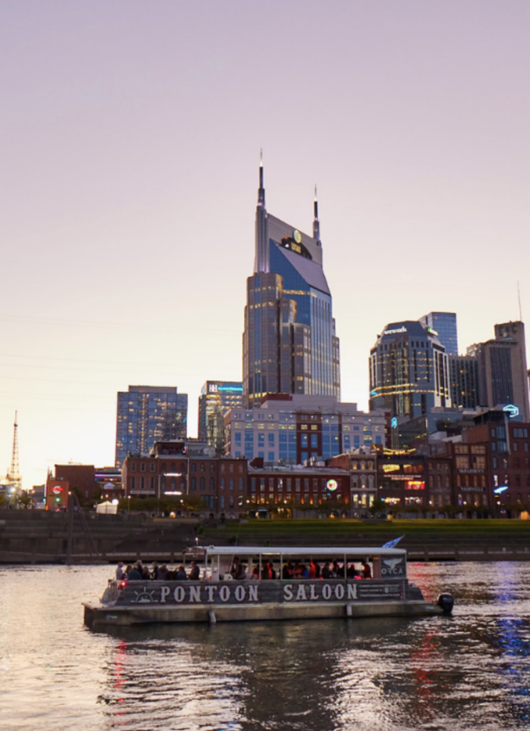 a small boat in a body of water with Nashville in the background