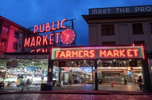 a store front at night with Pike Place Market in the background