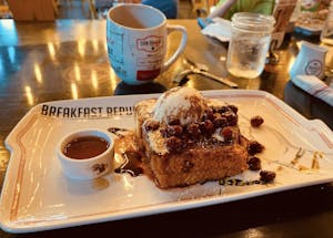 a piece of french toast and a cup of coffee on a table