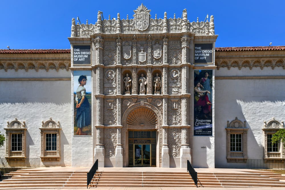 a group of people walking in front of San Diego Museum of Art
