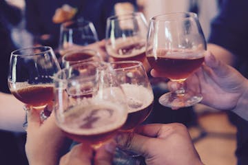 A group toast with beer tasting glasses