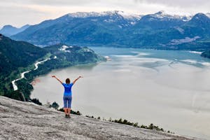 Hiking near Vancouver. Young woman on cliff over the ocean. Stawamus Chief Peak. Squamish. Whistler. British Columbia. Canada.