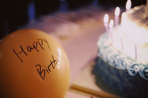 Birthday cake, and balloon with Happy Birthday written on it.