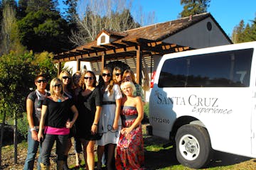Wine tour participants posing near shuttle van