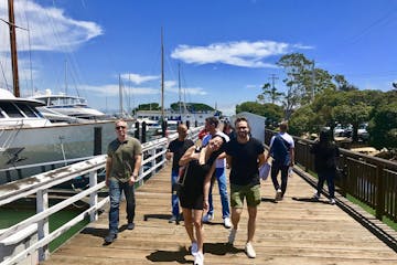Group of tourists walking on a dock in a boatyard in Sausalito, CA