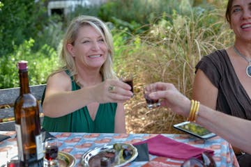 Two women cheer their glasses of wine outside at a winery in Yountville Napa
