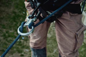 Safety attachments are attached to a student participating in the Zion Rappelling Course