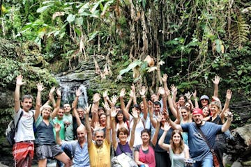 A tour group in El Yunque forest by a waterfall