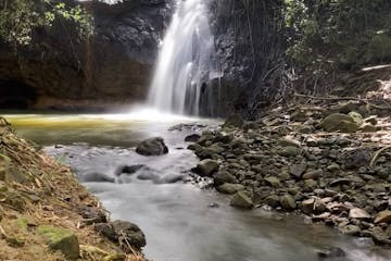 a large waterfall next to a rock
