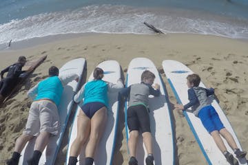 A family on the beach learning how to surf