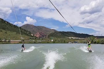 two people waterskiing from same boat