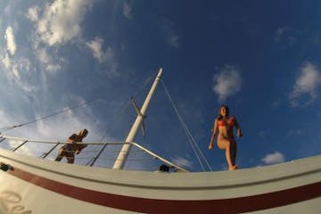 Girl jumping off of catamaran